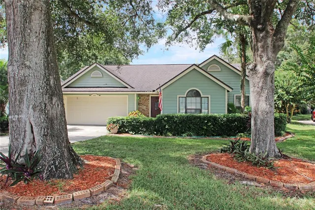 a front view of a house with a yard and trees
