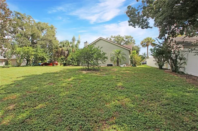 a view of a green field with some trees