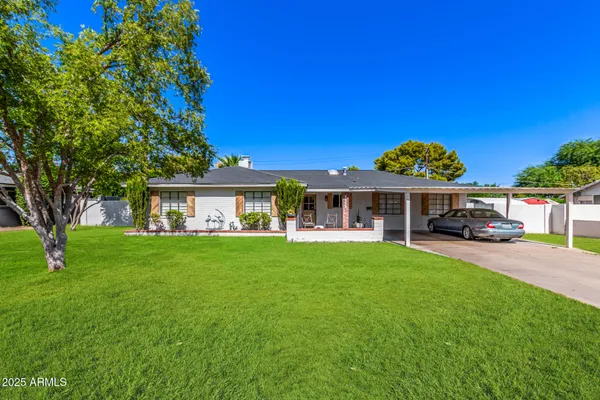 a view of a big yard with table and chairs under an umbrella