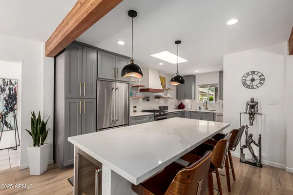 a kitchen with white cabinets and sink