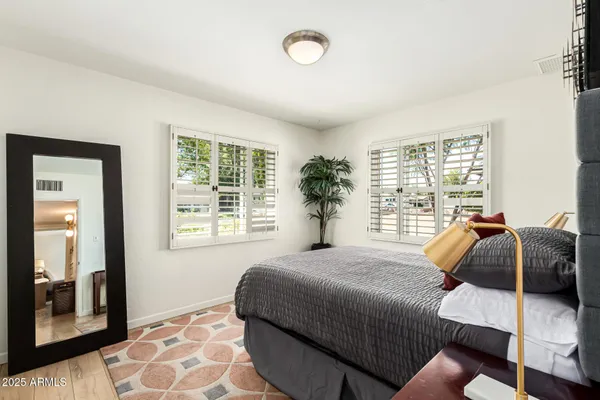 a bed sitting in a bedroom next to a window
