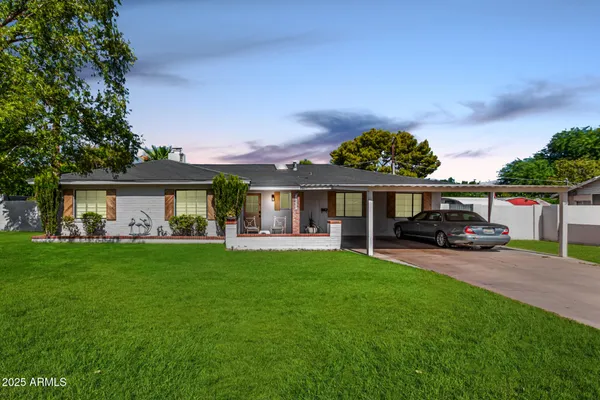 a view of a house with backyard and sitting area