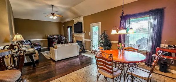 a dining room with wooden floor and chandelier