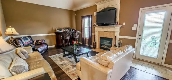 a living room with furniture a flat screen tv and a fireplace