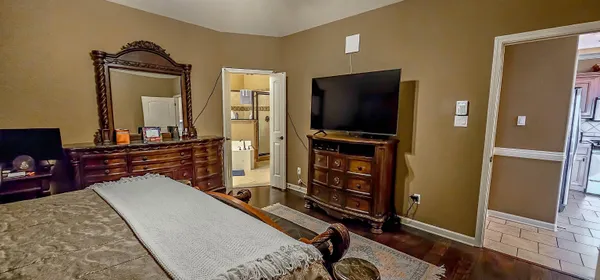 a living room with furniture flat screen tv and a refrigerator