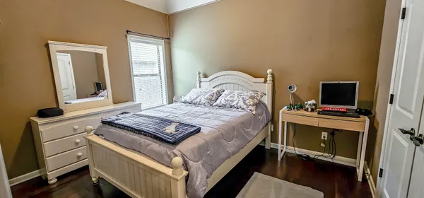 a bedroom with a bed and a flat tv screen on a dresser