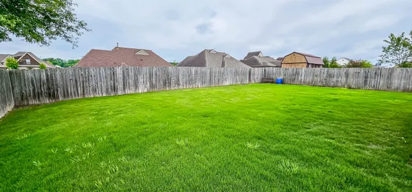 a view of a backyard with wooden fence