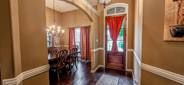 a view of a hallway with furniture and chandelier
