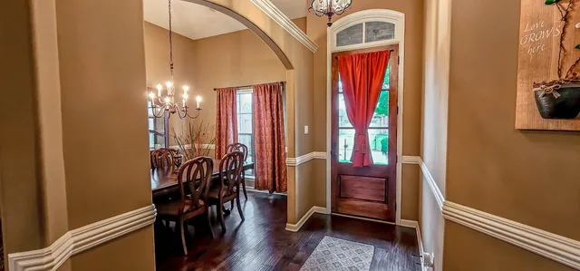 a view of a hallway with furniture and chandelier