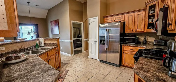 a kitchen with stainless steel appliances granite countertop a refrigerator and a stove top oven