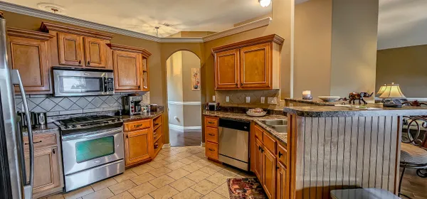 a kitchen with stainless steel appliances granite countertop a stove a sink and a microwave