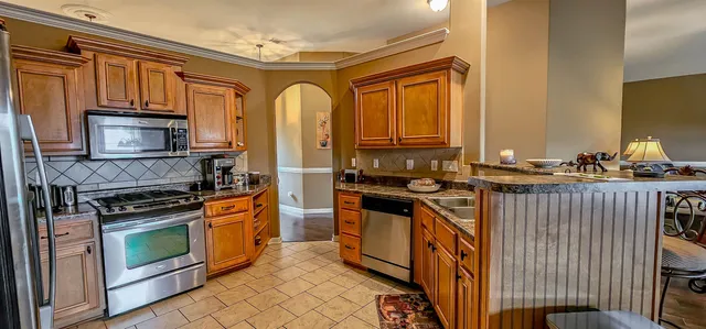 a kitchen with stainless steel appliances granite countertop a stove a sink and a microwave