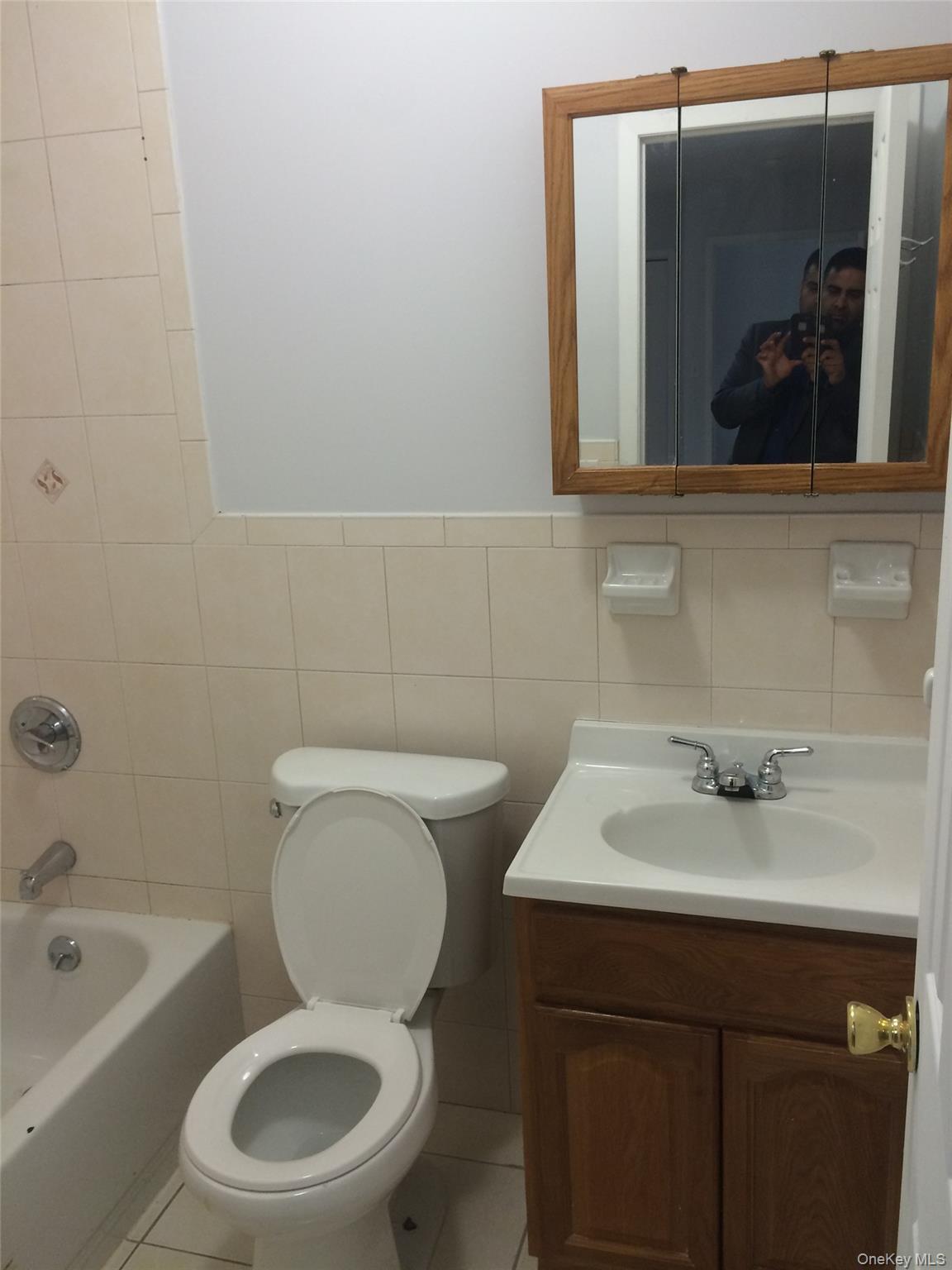 97-56 105th Street, Unit 2 Queens, NY 11416 - Photo 14 of 29 a bathroom with a toilet sink and mirror