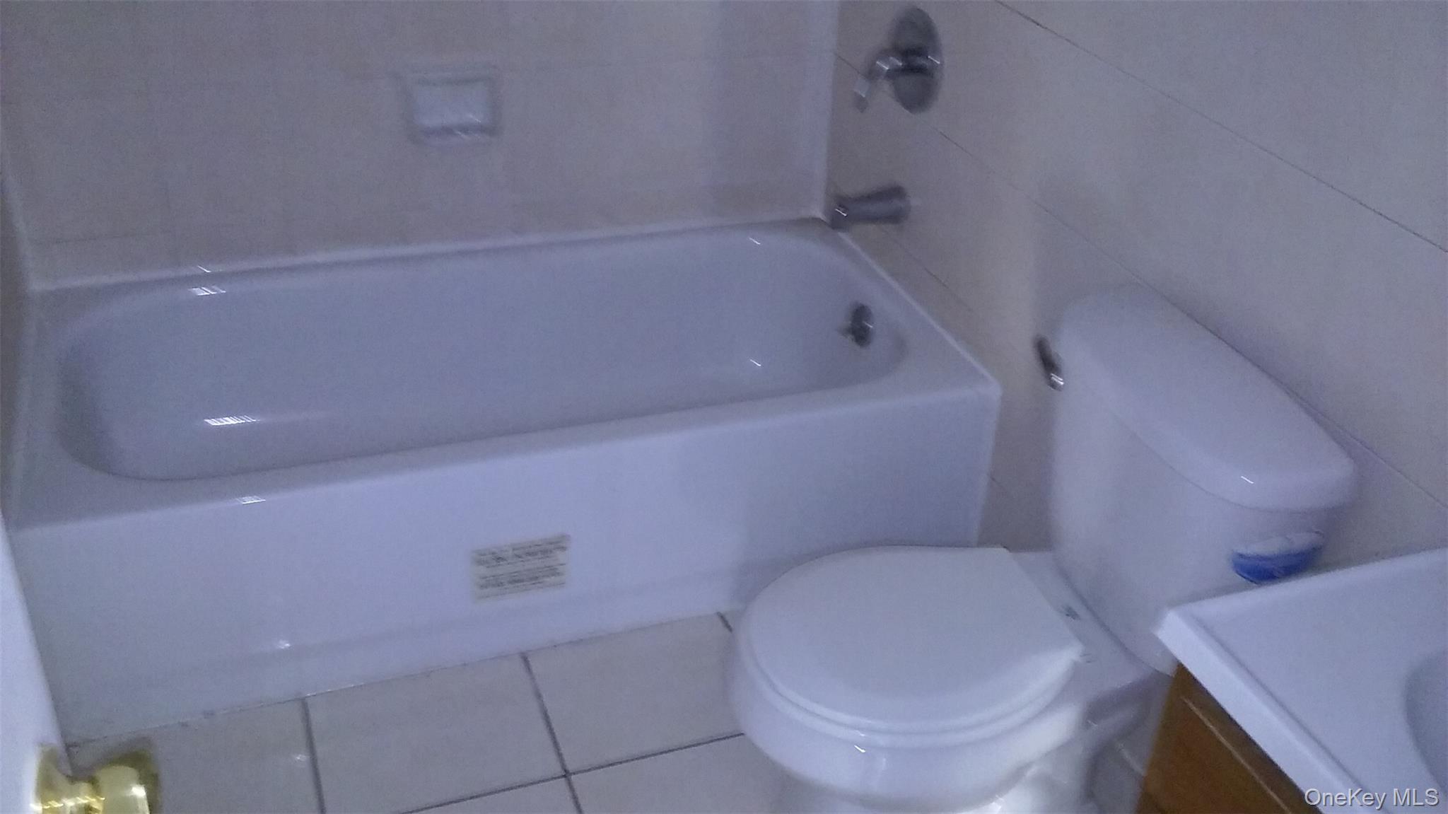 97-56 105th Street, Unit 2 Queens, NY 11416 - Photo 19 of 29 a bathroom with a toilet and a bathtub