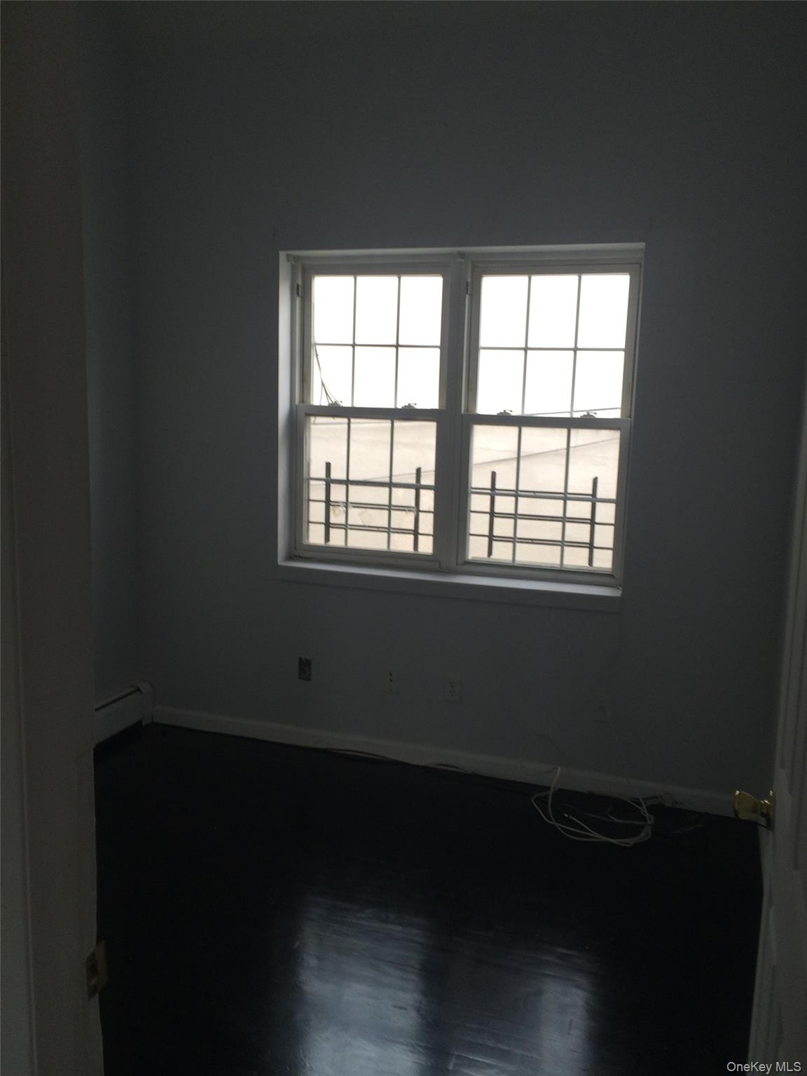 97-56 105th Street, Unit 2 Queens, NY 11416 - Photo 8 of 29 a view of an empty room with wooden floor and a window