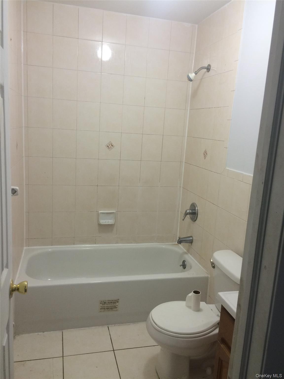 97-56 105th Street, Unit 2 Queens, NY 11416 - Photo 10 of 29 a view of a bathroom with a tub and toilet