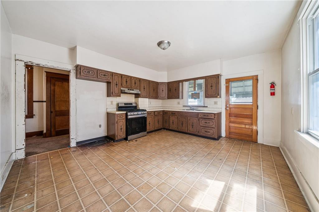 338 Catherine Street McKees Rocks, PA 15136 - Photo 14 of 25 a kitchen with stainless steel appliances a stove top oven and cabinets