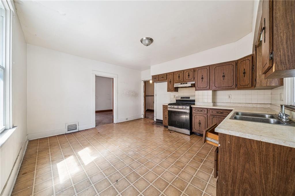 338 Catherine Street McKees Rocks, PA 15136 - Photo 16 of 25 a kitchen with stainless steel appliances granite countertop a stove a sink and a refrigerator