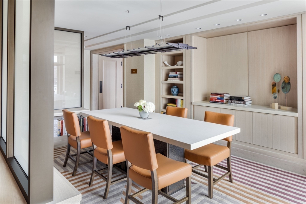 100 Lovejoy Wharf, Unit 6B Boston, MA 02114 - Photo 22 of 25 a dining room with a wooden table and chairs