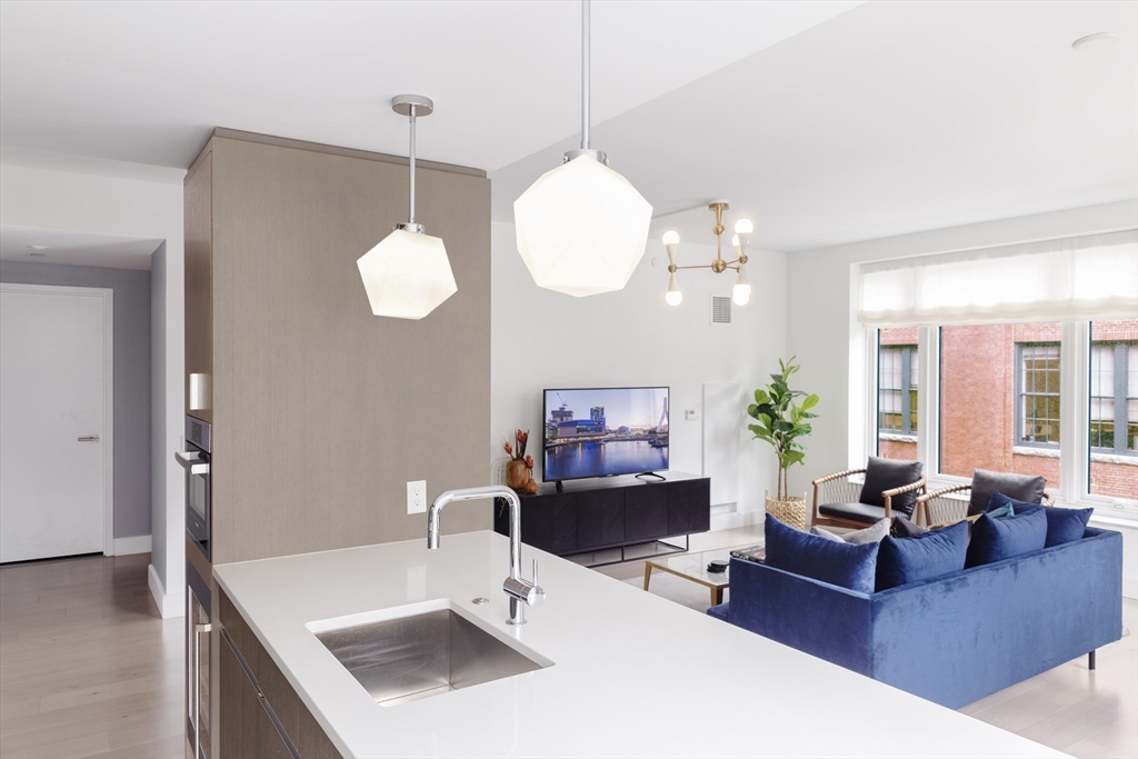 100 Lovejoy Wharf, Unit 6B Boston, MA 02114 - Photo 5 of 25 a living room with furniture a chandelier and a large mirror