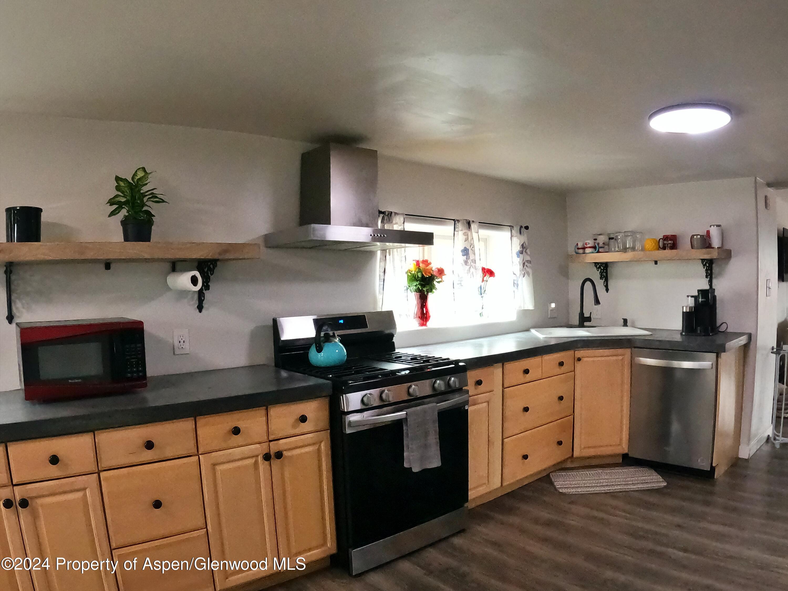 429 East 7th Street Rifle, CO 81650 - Photo 4 of 17 a kitchen with granite countertop white cabinets and white appliances
