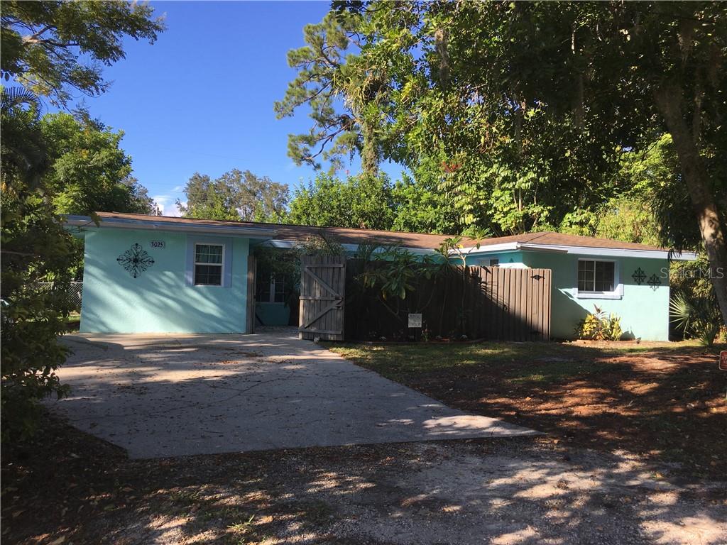 3025 Wilkinson Road Sarasota, FL 34231 - Photo 1 of 1 a view of a yard in front of a house with large trees