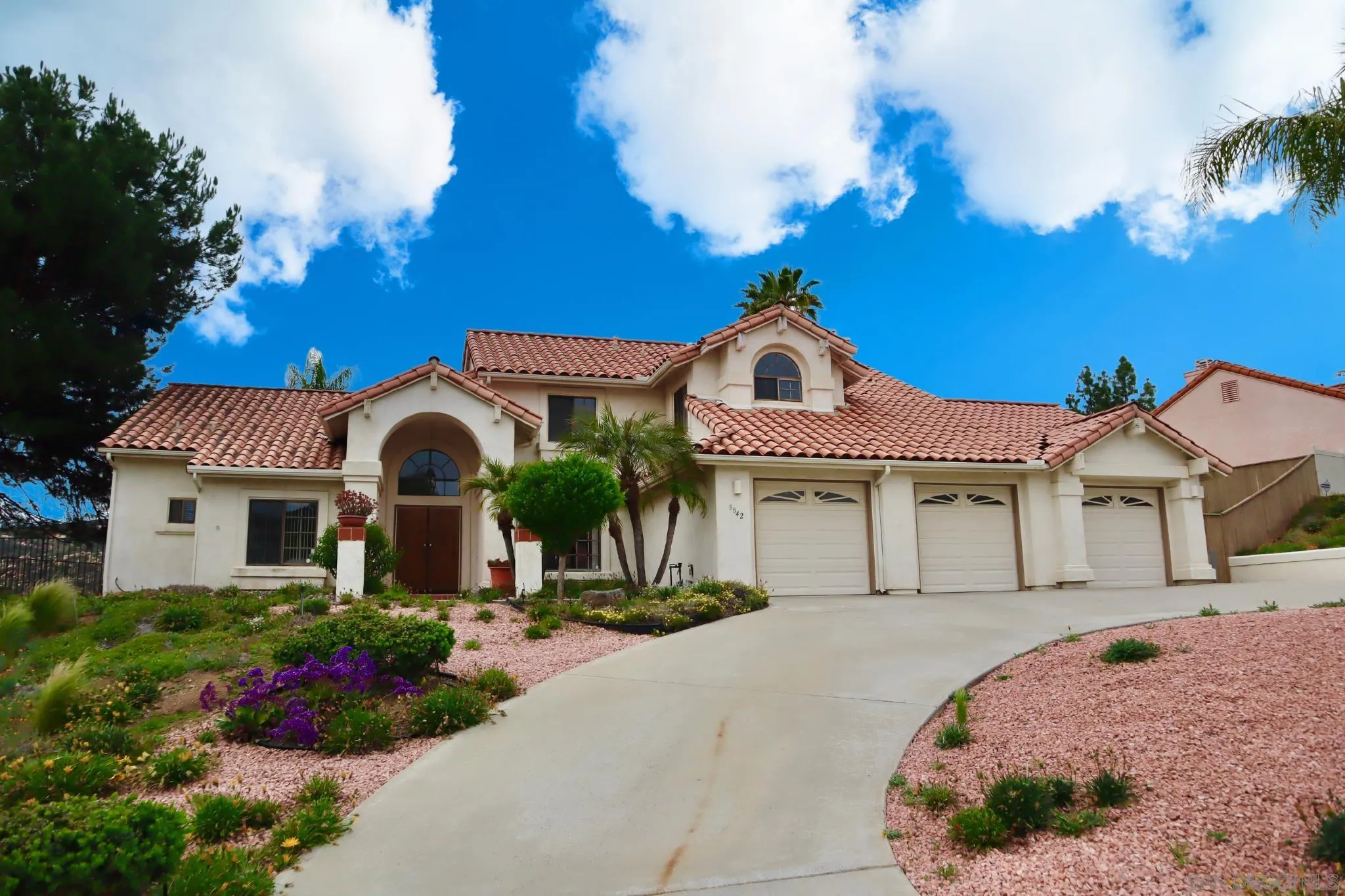 a front view of a house with a garden