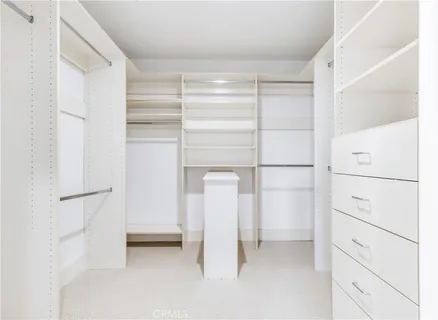 a view of walk in closet with empty racks