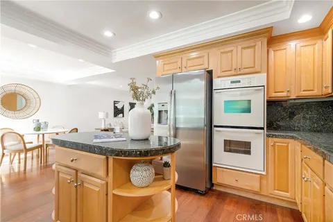 a kitchen with stainless steel appliances granite countertop a stove a refrigerator and a microwave