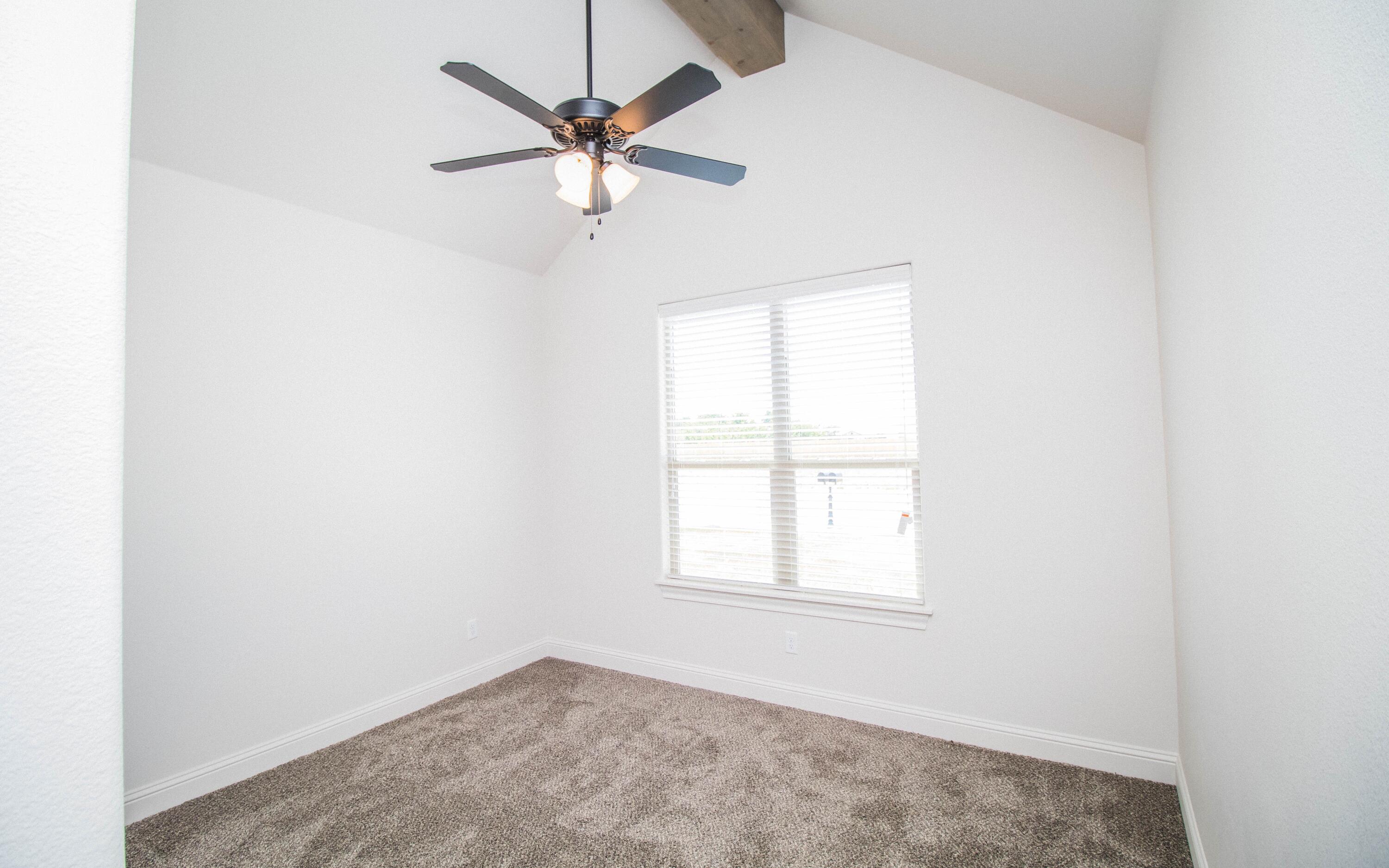 1613 102nd Street Lubbock, TX 79423 - Photo 14 of 18 an empty room with a window and a fan