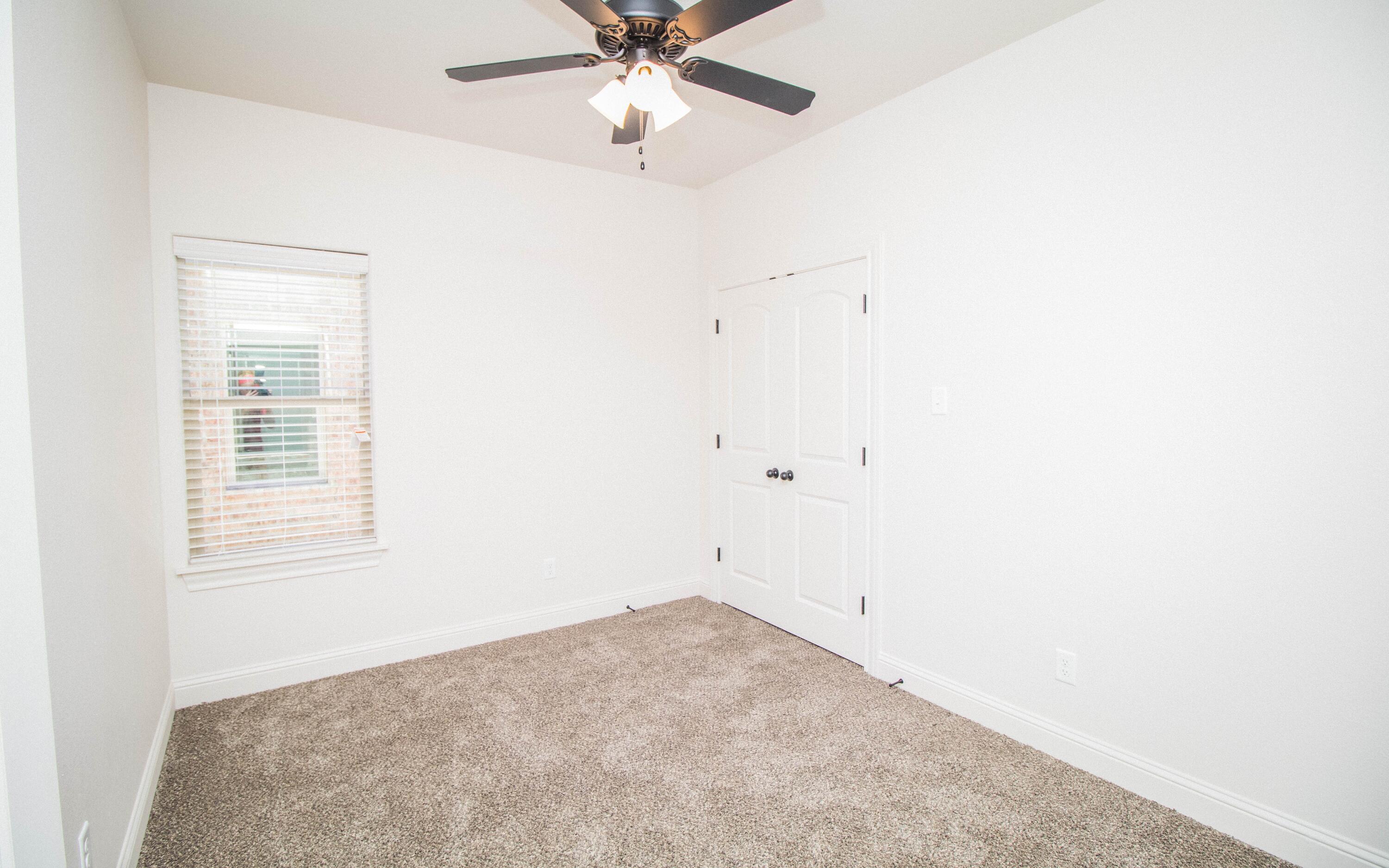 1613 102nd Street Lubbock, TX 79423 - Photo 15 of 18 an empty room with a window and a fan