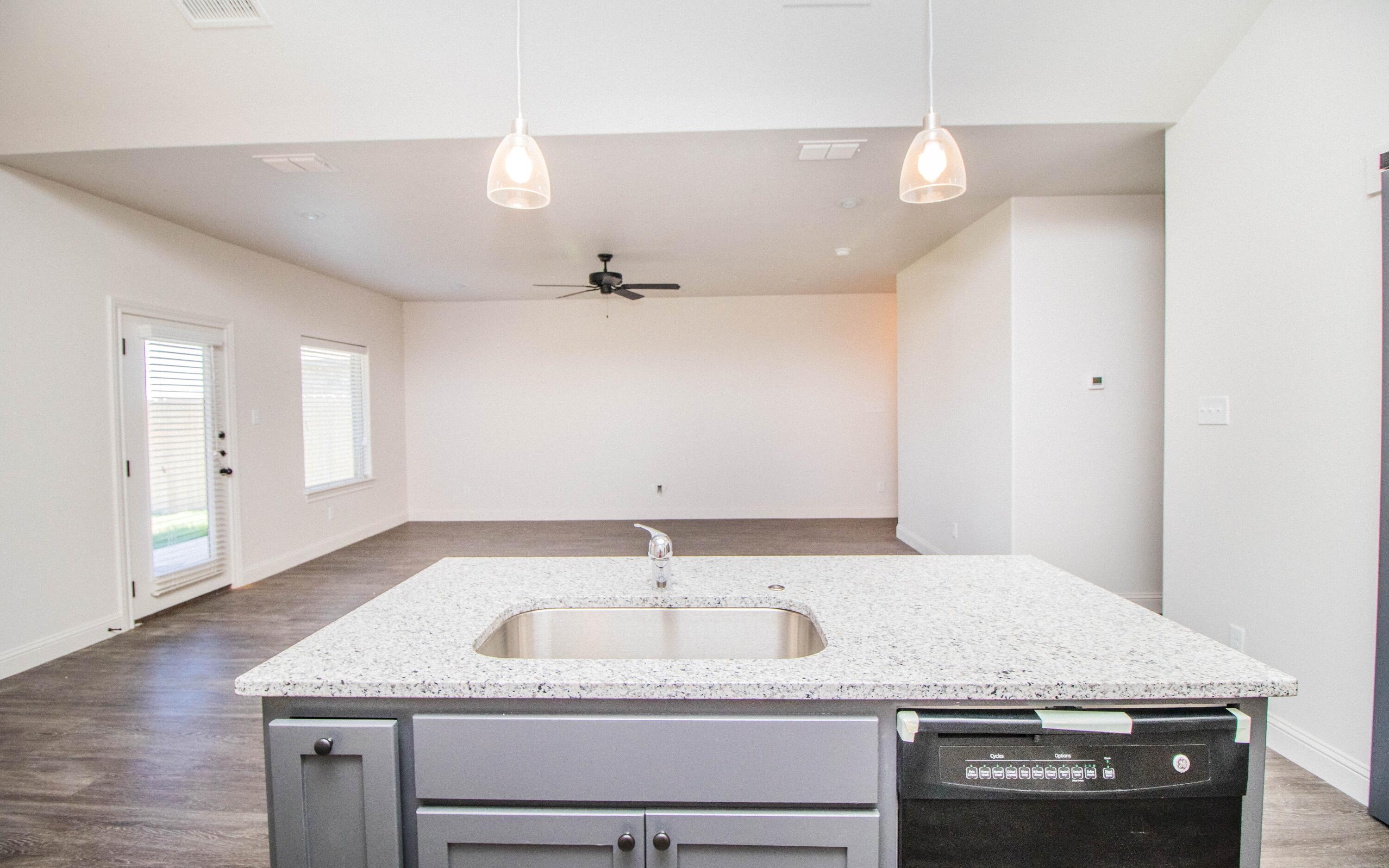 1613 102nd Street Lubbock, TX 79423 - Photo 5 of 18 a bathroom with a granite countertop sink and a mirror
