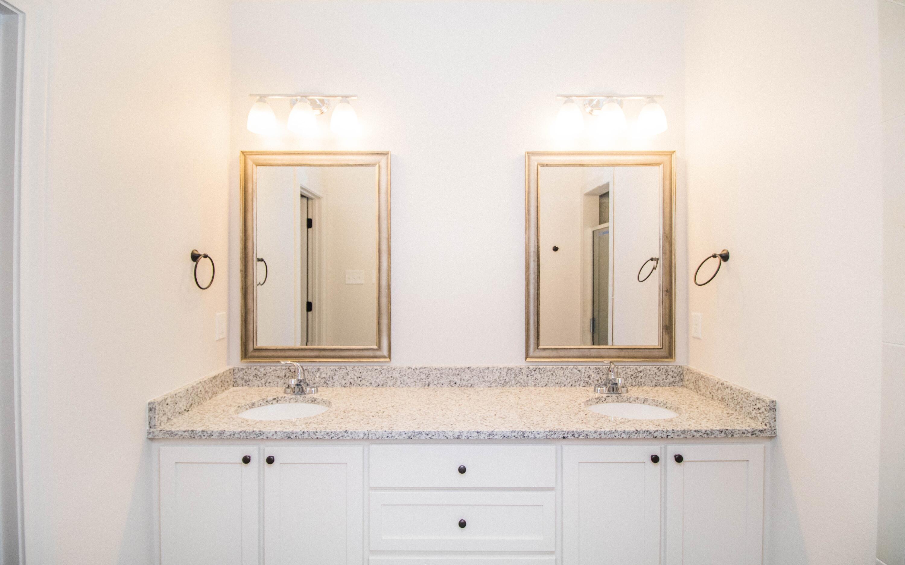 1613 102nd Street Lubbock, TX 79423 - Photo 9 of 18 a bathroom with a granite countertop sink and a mirror