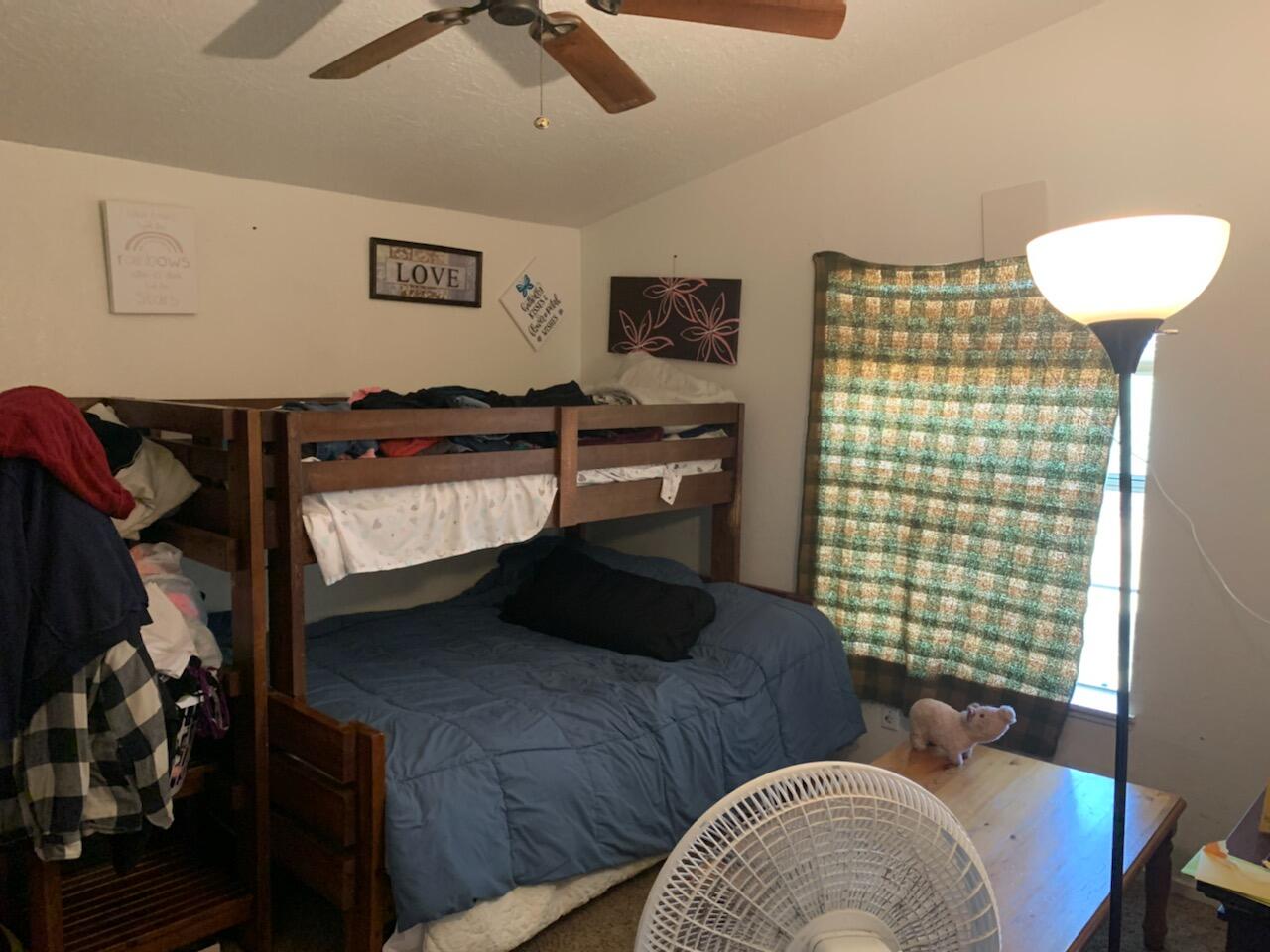 20567 Plymire Road Red Bluff, CA 96080 - Photo 14 of 20 a bedroom with a bed and a chandelier