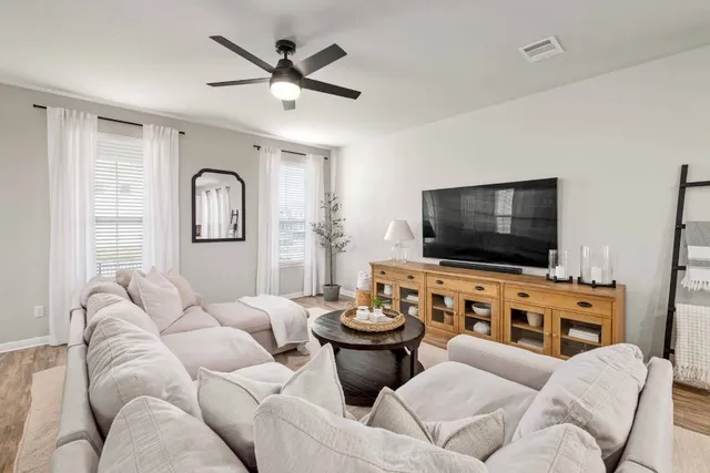 a living room with furniture a rug and a window