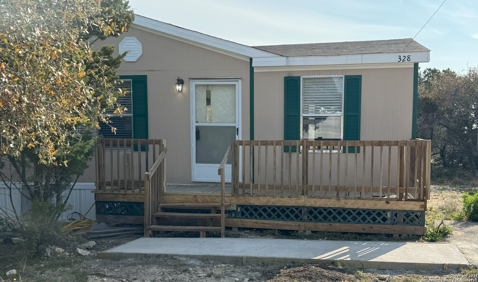 a view of wooden house with a small yard and wooden fence