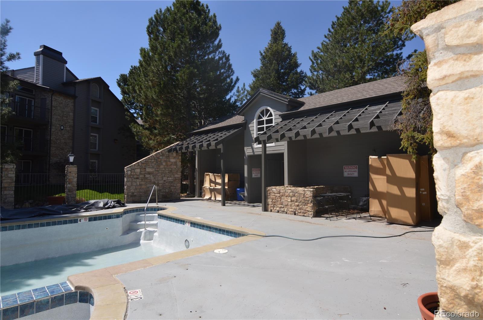 2575 South Syracuse Way, Unit J308 Denver, CO 80231 - Photo 14 of 14 a view of roof deck with table and chairs with wooden floor and fence