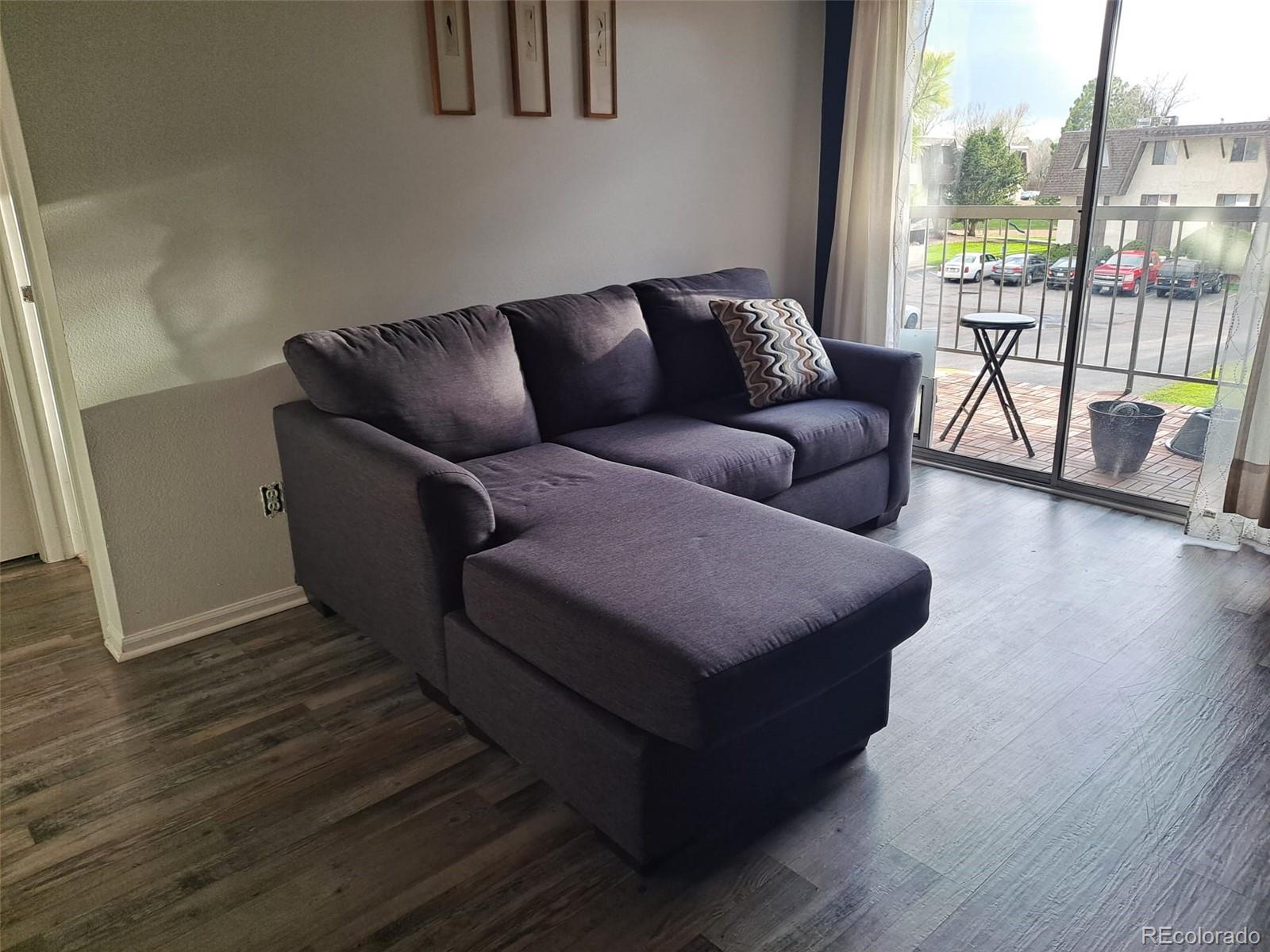 2575 South Syracuse Way, Unit J308 Denver, CO 80231 - Photo 5 of 14 a living room with furniture and a floor to ceiling window