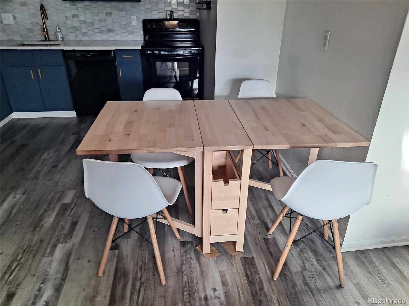 2575 South Syracuse Way, Unit J308 Denver, CO 80231 - Photo 9 of 14 a dinning table and chairs in a kitchen