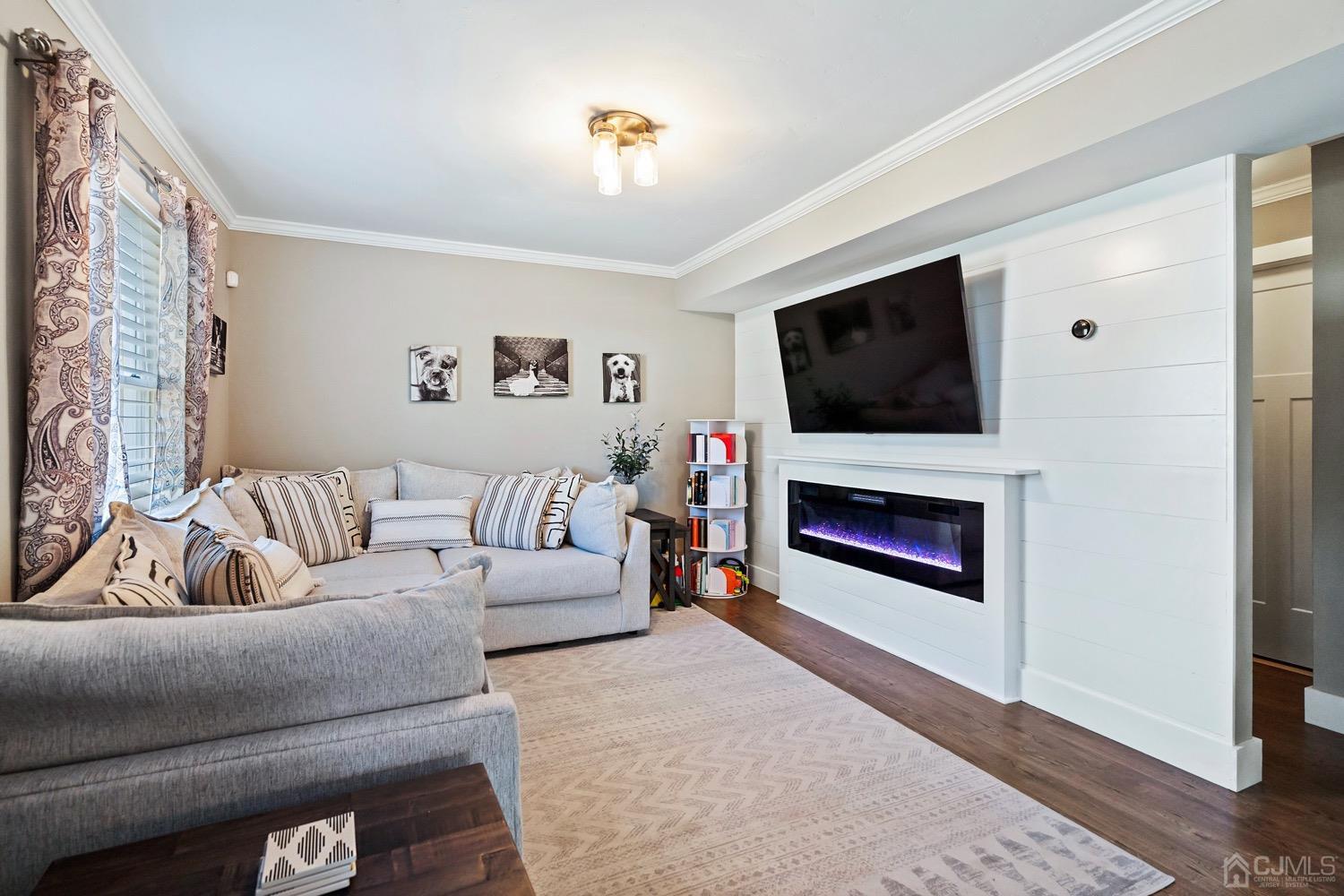 a living room with furniture a flat screen tv and a fireplace