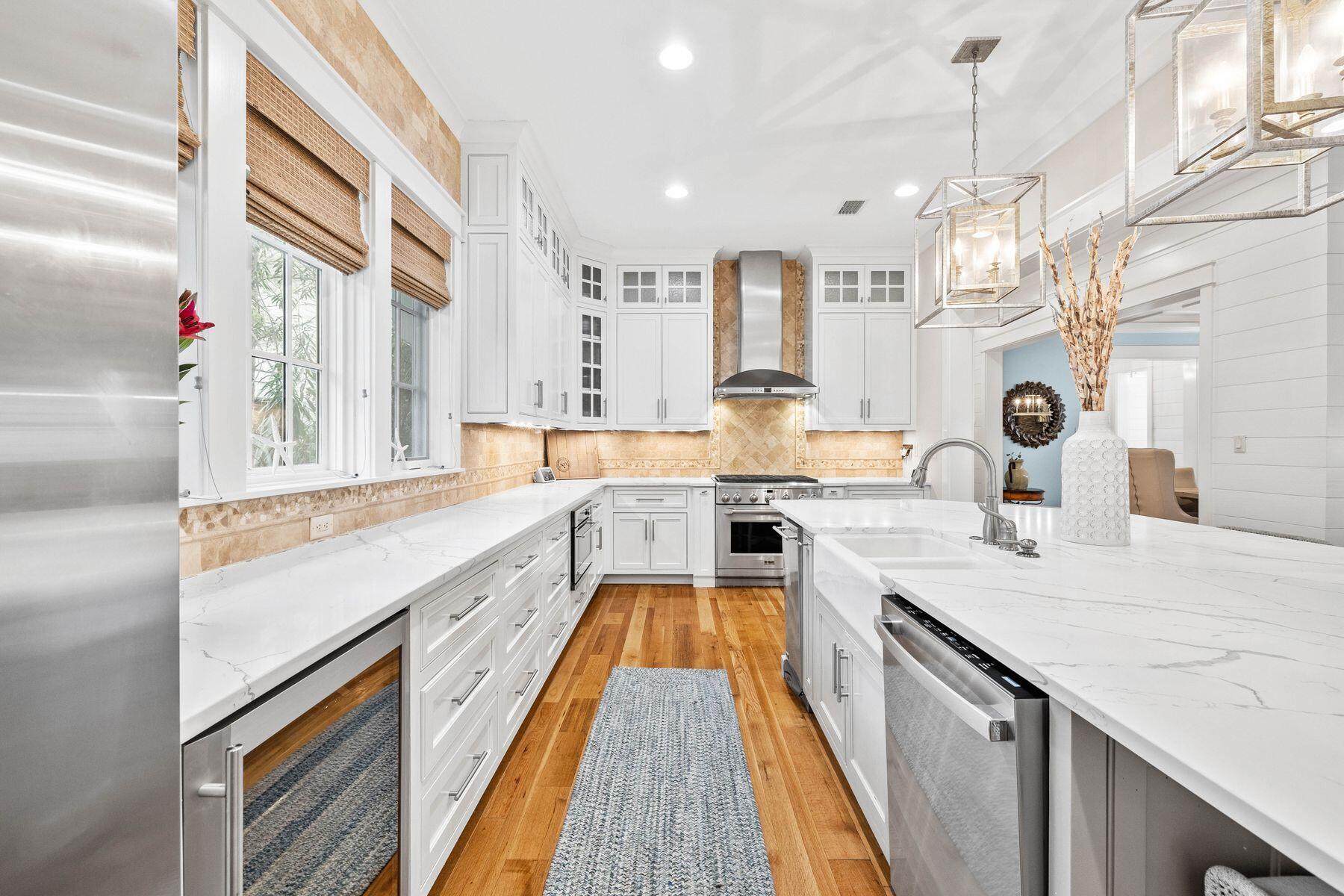 76 Tidepool Lane Watersound, FL 32461 - Photo 8 of 41 a view of a kitchen with kitchen island a large counter top space a sink stainless steel appliances and cabinets
