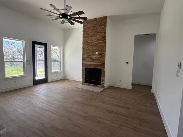 an empty room with windows and a fireplace