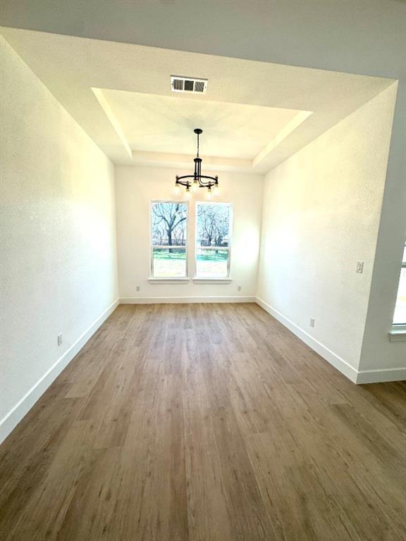 1106 East Sixth Street Springtown, TX 76082 - Photo 12 of 25 an empty room with wooden floor and windows