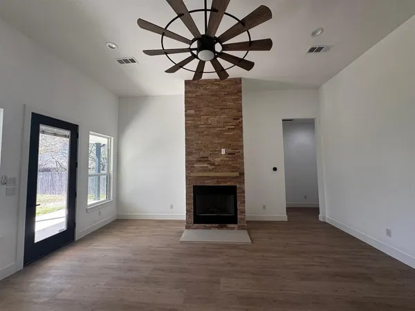 a view of an empty room with a fireplace and a window
