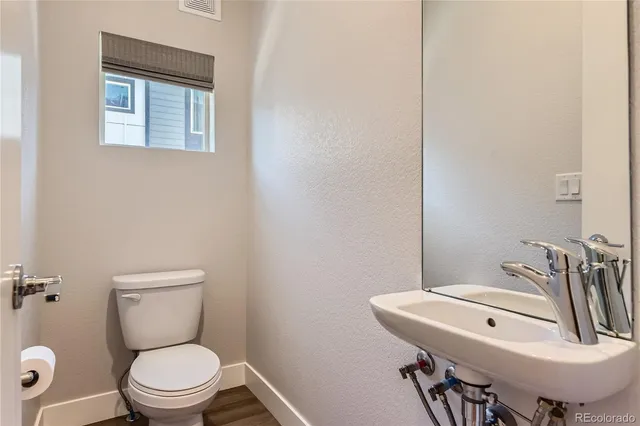 a bathroom with a toilet a sink and a mirror