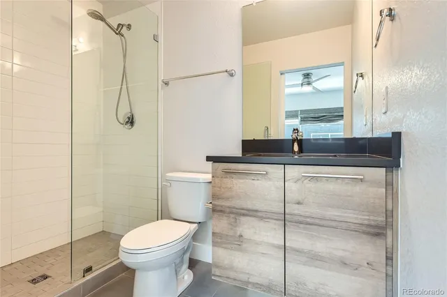 a bathroom with a granite countertop sink toilet and shower