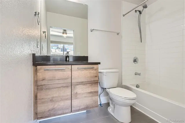 a bathroom with a granite countertop sink toilet and shower