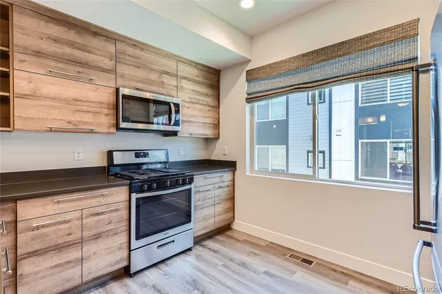 a kitchen with stainless steel appliances a stove microwave and sink