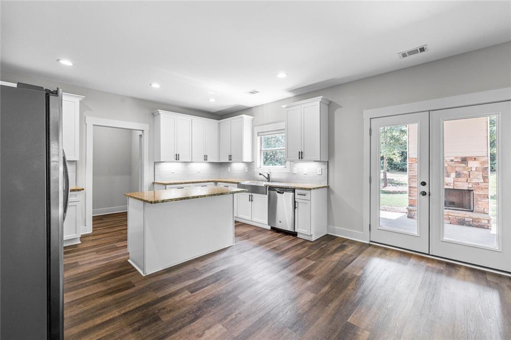 1701 Trotters Court Monroe, GA 30656 - Photo 16 of 41 a kitchen with wooden floors and refrigerator
