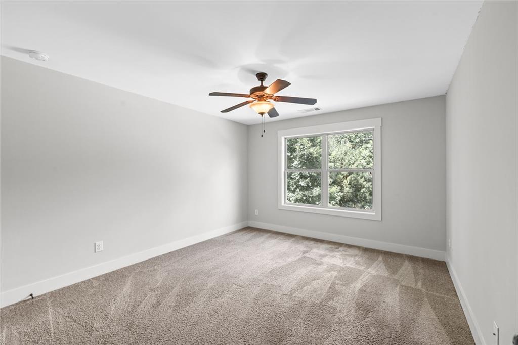 1701 Trotters Court Monroe, GA 30656 - Photo 32 of 41 an empty room with windows and a ceiling fan